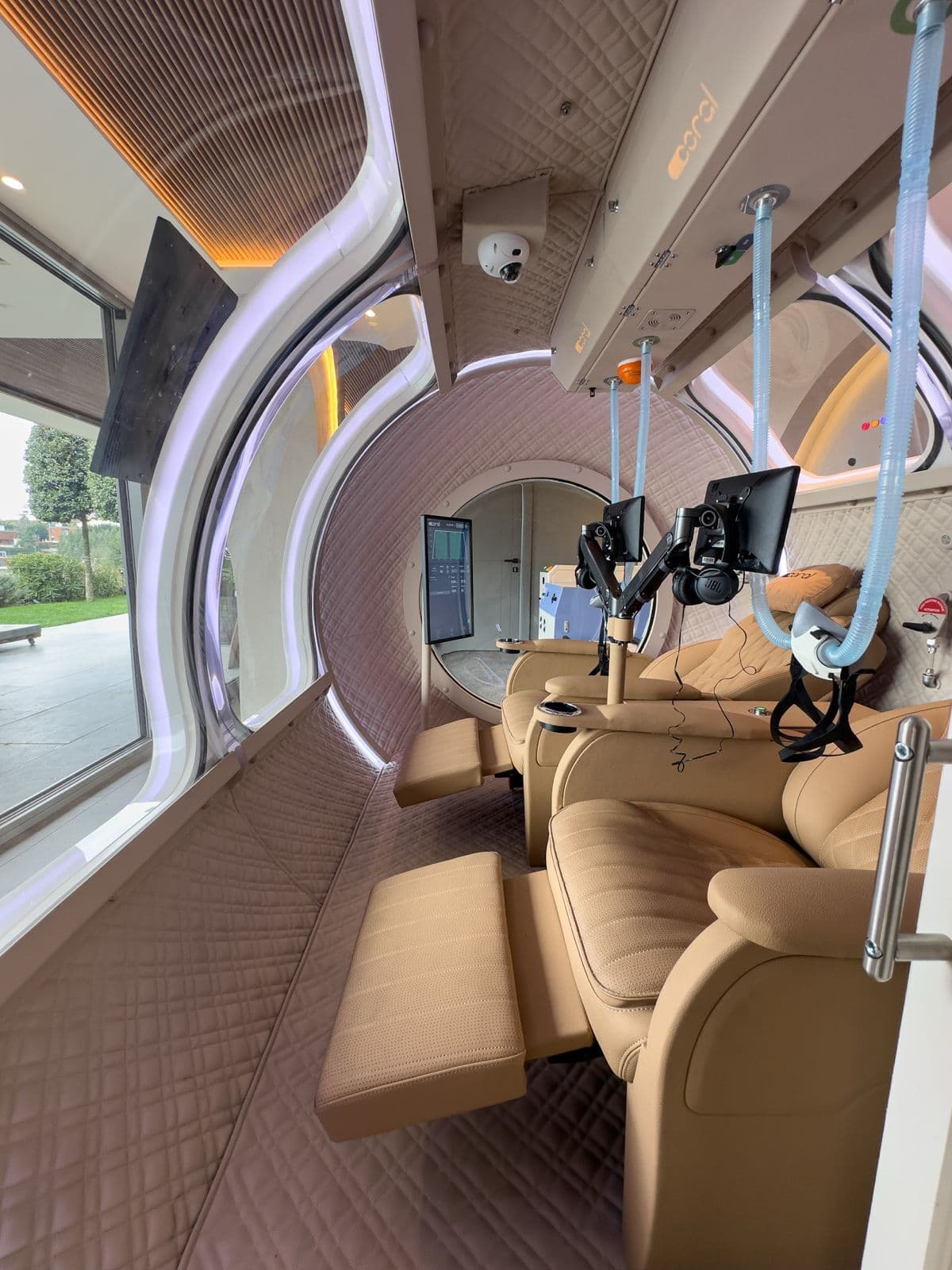 Inside the Coral Ark cabin, quilted leather recliners and oxygen masks with the landscape through the window