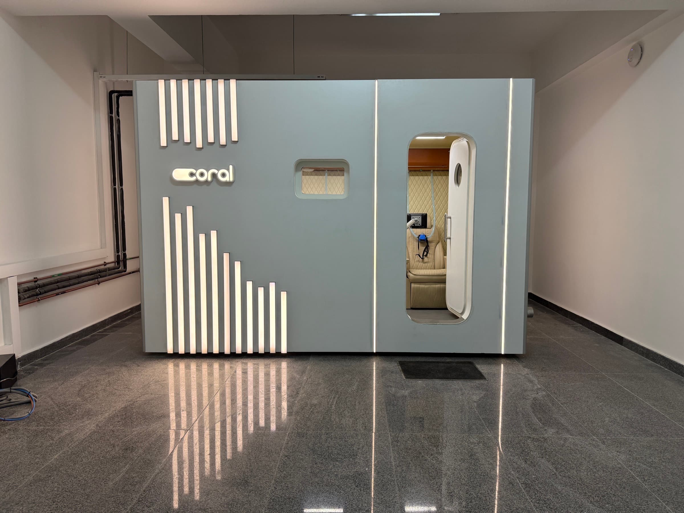 Coral Cube exterior with LED accent strips, side-entry door open to the cabin