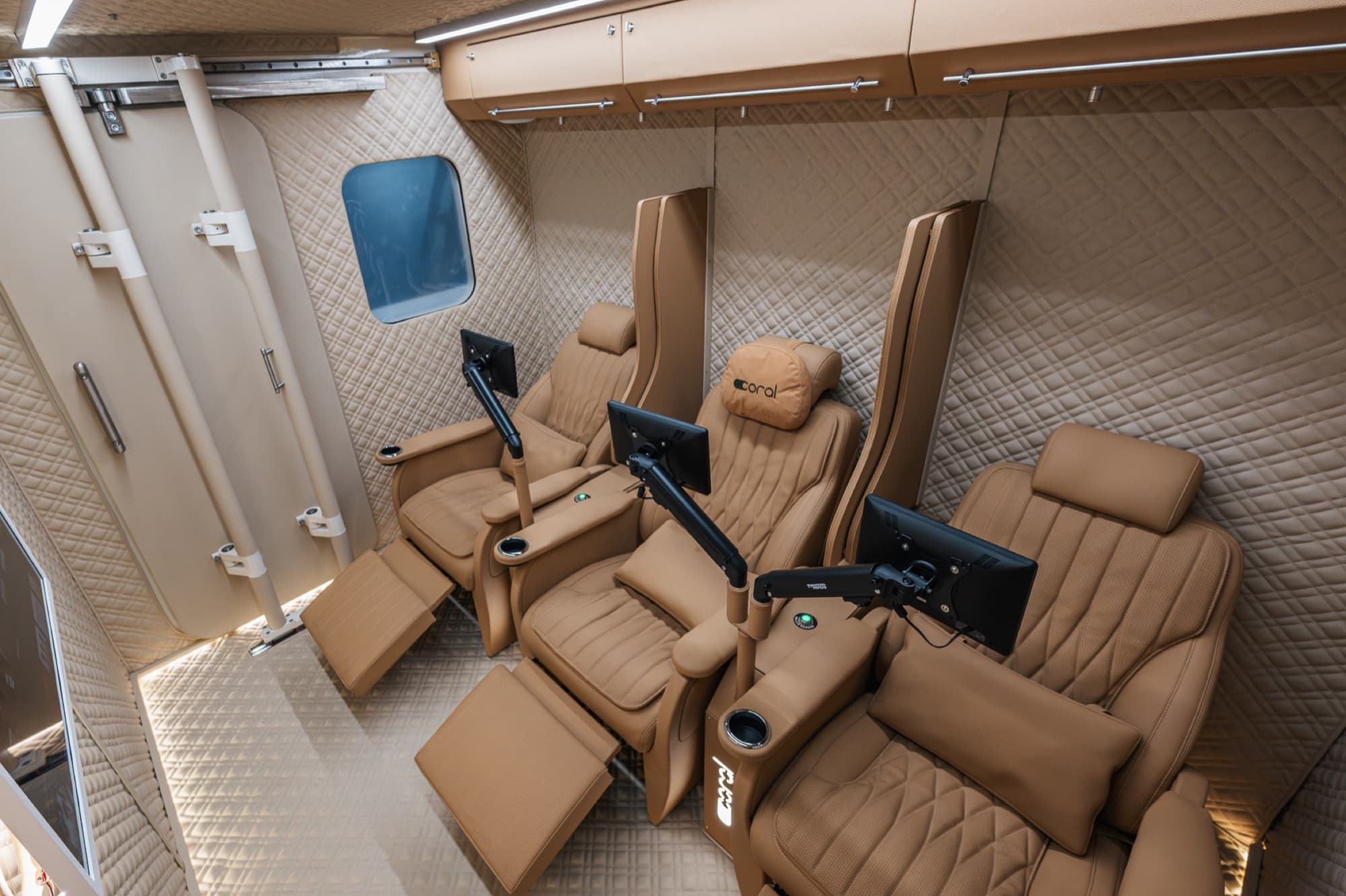 Coral Cube cabin in Rwanda, beige leather seats with monitor arms