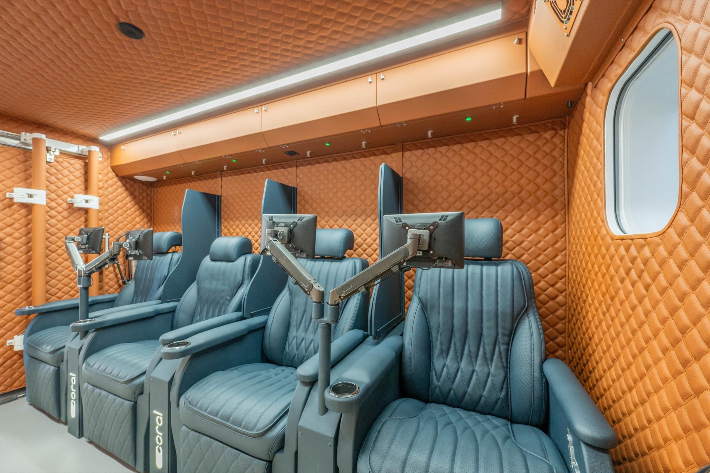 Coral Cube interior, dark green leather reclining seats under warm light