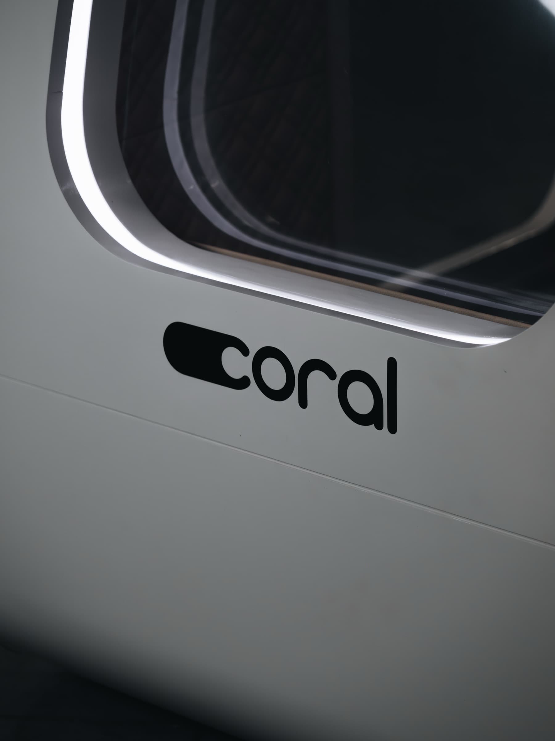 Close-up of the Coral Pod exterior showing the window and coral branding